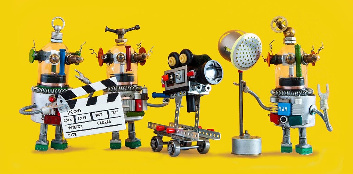 Eine Gruppe Roboter gebastelt aus Elektronikteilen. Einer hält eine Filmklappe, einer eine Kamera und eine einen Salzstreuer, der einen Scheinwerfer darstellt.