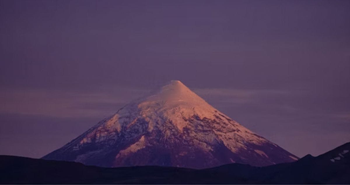 Eine Bergkuppe vor dem violetten Nachthimmel