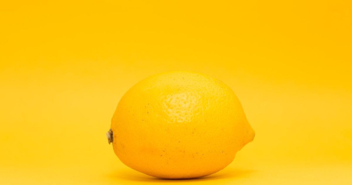 auf dem Bild ist eine leuchtend gelbe Zitrone mittig vor einem ebenso gelben Hintergrund platziert.